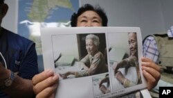 South Korean Shin Yun-sun shows photos of her 92-year-old mother, Baek Bong-rye, during an interview at her house in Seoul, South Korea Wednesday, July 29, 2020. (AP Photo/Ahn Young-joon)