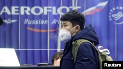 2020年2月4日，一名戴著口罩的旅客在俄羅斯謝列梅捷沃國際機場的俄羅斯航空公司訂票櫃檯旁。 （2020年2月4日）