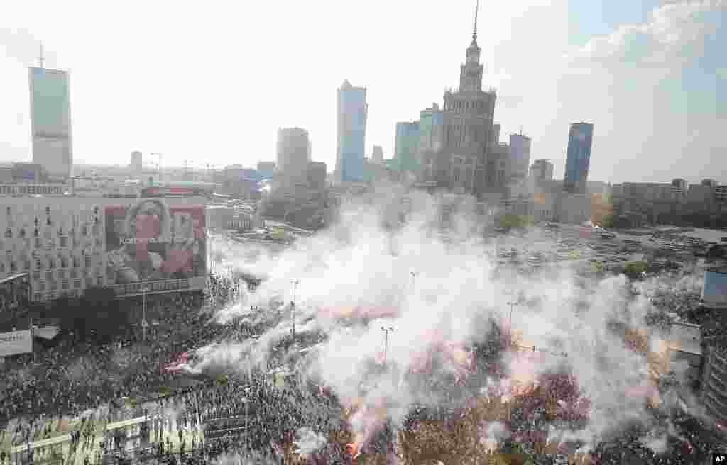 Warsaw residents stand with national flags and flares to observe a minute of silence for the fighters and victims of the 1944 Warsaw Rising against the Nazi German occupiers, on the 74th anniversary of the revolt, in downtown Warsaw, Poland.