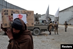 Avganistanac nosi paket koji je podijelila turska humanitarna grupa u distributivnom centru u Kabulu, Afganistan, 15. decembra 2021.