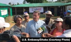 FILE - USAID Administrator Mark Green, center, speaks to reporters at the Balukhali Rohingya refugee camp in Cox’s Bazar, Bangladesh, May 15, 2018. He says a new measure promoting U.S. prviate investment in developing countries will aid their economies and 'advance foreign policy interests.'.