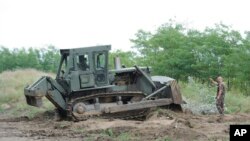 A bulldozer of the Hungarian Defense Force is used to prepare the terrain for the building of at the Hungarian-Serbian border near Morahalom, 179 kms southeast from Budapest, July 13, 2015. 