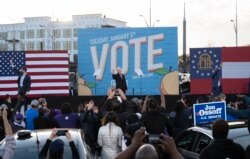 Jon Ossoff (kushoto), Raphael Warnock (Kulia) na Rais mteule Joe Biden (katikati) wakiwa katika kampeni uwanja wa Center Parc Atlanta, Georgia, on January 4, 2021.