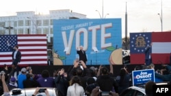 Democratic candidates for Senate Jon Ossoff (L), Raphael Warnock (R) and US President-elect Joe Biden (C) wave from stage during a rally outside Center Parc Stadium in Atlanta, Georgia, on January 4, 2021. - President Donald Trump, still seeking ways to r