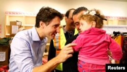 Syrian refugees are greeted by Canada's Prime Minister Justin Trudeau in 2015.