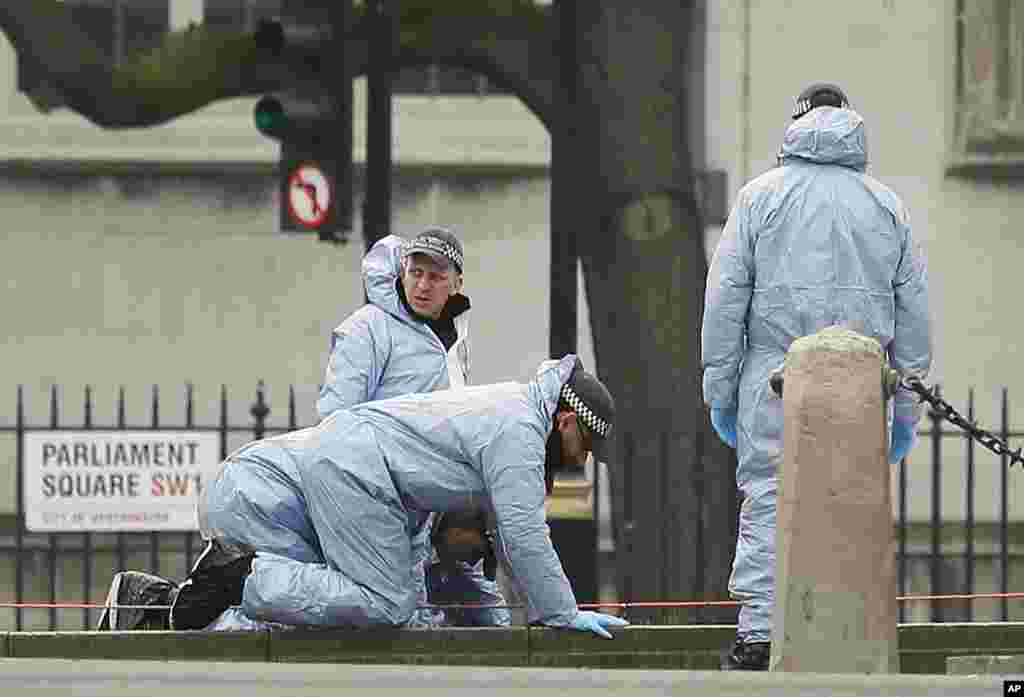 Police forensic officers work in Parliament Square outside the Houses of Parliament in London, March 23, 2017. 