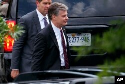FBI Director Christopher Wray, right, leaves the White House in Washington, May 21, 2018.