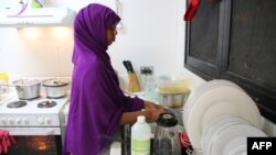 FILE - A refugee from Somalia, who had previously attempted to commit suicide, is seen doing kitchen chores at Camp Five on the Pacific island of Nauru, Sept. 2, 2018.