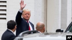 Republican presidential candidate Donald Trump waves as he arrives for a meeting with House Speaker Paul Ryan of Wis., at the Republican National Committee Headquarters on Capitol Hill in Washington, May 12, 2016. 