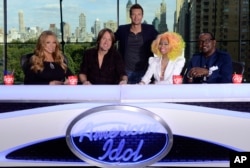 This photo provided by Fox, American Idol host Ryan Seacrest, center, poses with judges, from left, Mariah Carey, Keith Urban, Nicki Minaj and Randy Jackson, Sept. 16, 2012 in New York.