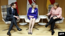 Le Premier ministre britannique Theresa May, la chancelière allemande Angela Merkel et le président français Emmanuel Macron suite à une réunion en marge du sommet des dirigeants européens à Bruxelles, le 22 mars 2018.