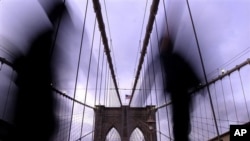 New Yorkers walk across the Brooklyn Bridge. 