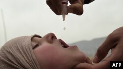 An Afghan health worker administers the polio vaccine to a child during a vaccination campaign in Kabul on February 28, 2017.