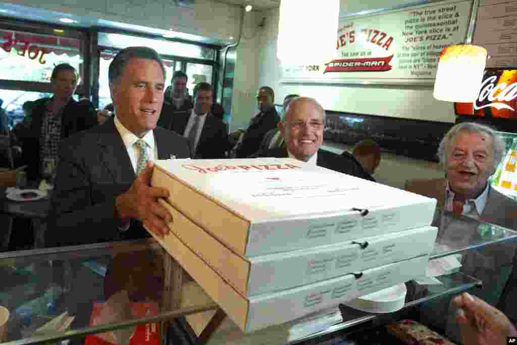 Republican presidential candidate, former Massachusetts Gov. Mitt Romney, accompanied by former New York City Mayor Rudy Giuliani, picks up pizza for firefighters in New York, May 1, 2012. (AP)