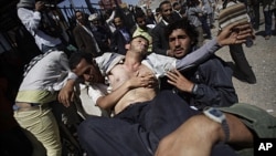 A Yemeni wounded protestor is carried from the site of clashes with security forces in Sanaa, Yemen, October 25, 2011.