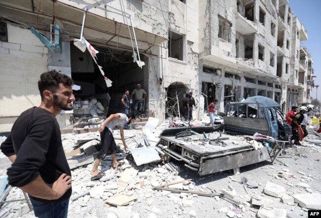 シリア人は、シリアの北西部の都市Idlib（2018年8月2日）に車の爆弾の場所に集まっている。