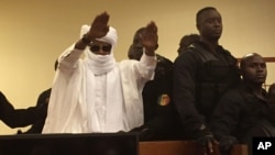 FILE - Chad's former dictator Hissene Habre raises his hands after sentencing during court proceedings in Dakar, Senegal, May 30, 2016. 