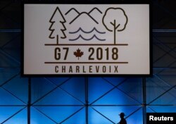 A Canadian mounted police officer walks past the Charlevoix G-7 logo at the main press center, ahead of G-7 Summit in Quebec, Canada, June 6, 2018.
