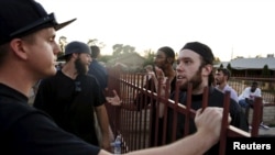 Members of the Islamic Community Center, including Ilyas Wadood, right, talk with people attending the "Freedom of Speech Rally Round II" outside the center in Phoenix, Arizona, May 29, 2015. 