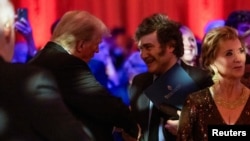 El presidente artentino, Javier Milei, saluda al presidente electo de EEUU durante una gala del America First Policy Institute en Mar-a-Lago, Florida, el 14 de noviembre de 2024.