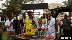 Seorang pengunjung memasak bersama seorang koki di festival Dubai Taste saat para pencinta kuliner dan koki internasional berkumpul untuk menghabiskan akhir pekan dengan kegiatan kuliner di Dubai, Uni Emirat Arab, 14 Februari 2025. (Rula Rouhana/REUTERS)