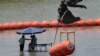 Trabajadores toman un descanso de colocar boyas para que sean utilizadas como barrera fronteriza en el río Bravo, el miércoles 12 de julio de 2023, a la altura de Eagle Pass, Texas. (AP Foto/Eric Gay)