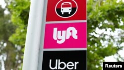 FILE PHOTO: A sign marks a rendezvous location for Lyft and Uber users at San Diego State University in San Diego, California, U.S., May 13, 2020. REUTERS/Mike Blake/File Photo