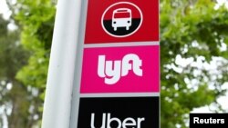 FILE PHOTO: A sign marks a rendezvous location for Lyft and Uber users at San Diego State University in San Diego, California, U.S., May 13, 2020. REUTERS/Mike Blake/File Photo