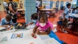 FILE — In this Aug. 17, 2021 file photo, students write and draw positive affirmations on poster board at P.S. 5 Port Morris, an elementary school in The Bronx borough of New York. New York City will phase out its program for gifted and talented students 