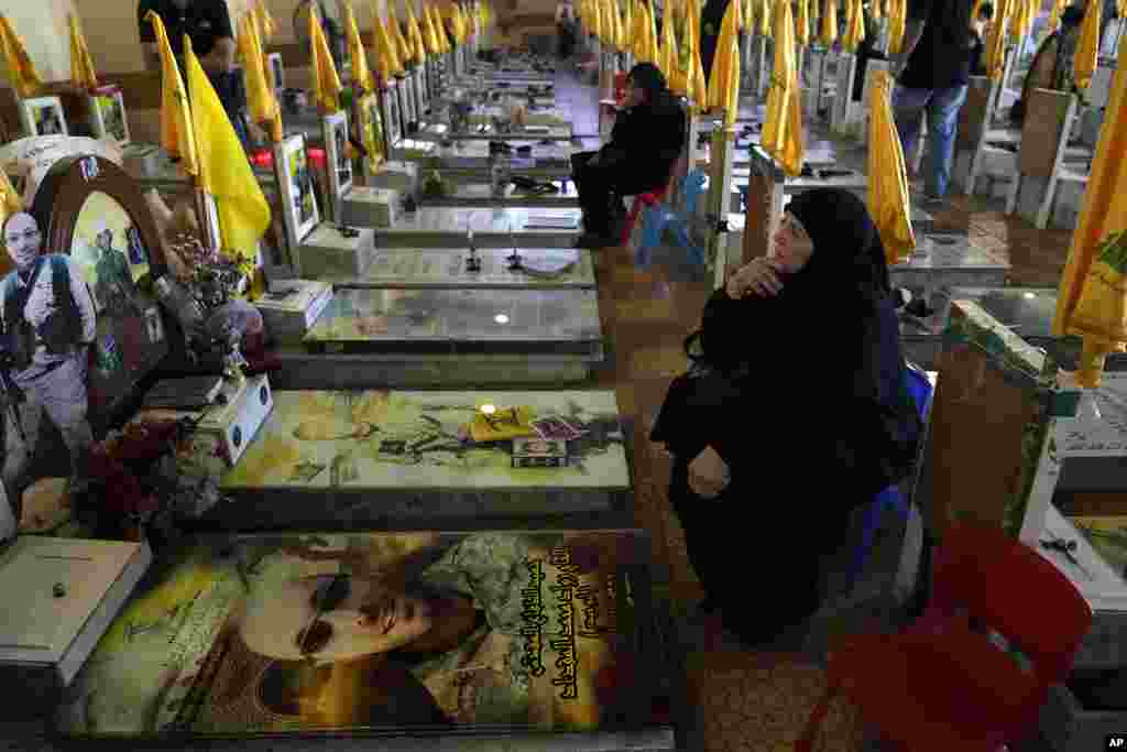 Women sit in a cemetery as they visit the graves of killed Hezbollah members in the southern suburbs of Beirut.