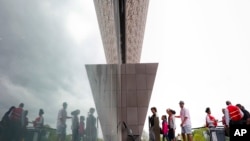 Visitors are reflected as they enter the Smithsonian National Museum of African American History and Cultural on the National Mall in Washington, May 1, 2017.