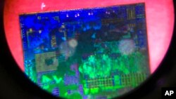 ফাইল - বেইজিং-এ আন্তর্জাতিক হাই টেক এক্সপো-তে একটি চাইনিজ মাইক্রোচিপ দেখা যাচ্ছে। ১৭ মে ২০১৮। 