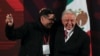 El presidente de México, Andrés Manuel López Obrador, abraza a un periodista que ganó un reloj sorteado entre miembros de los medios de comunicación durante su última conferencia de prensa, en Palacio Nacional, en la Ciudad de México, México, el 30 de septiembre de 2024.