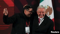 El presidente de México, Andrés Manuel López Obrador, abraza a un periodista que ganó un reloj sorteado entre miembros de los medios de comunicación durante su última conferencia de prensa, en Palacio Nacional, en la Ciudad de México, México, el 30 de septiembre de 2024.