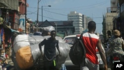 FILE - A man carts goods inside a market in Lagos, Nigeria, June 7, 2021. Nigeria's government announced at that time that it was suspending Twitter indefinitely. Twitter had recently deleted a controversial tweet President Muhammadu Buhari made about a secessionist movement.