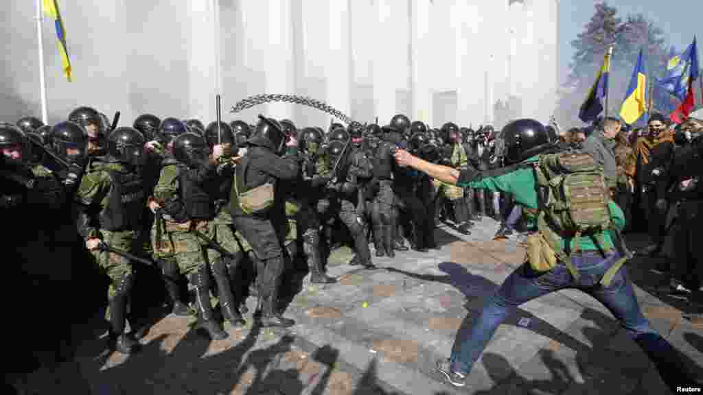 Protesters, right, clash with Interior Ministry and law enforcement members during a rally near the parliament building in Kyiv, Oct. 14, 2014. Thousands of Svoboda nationalist party supporters rallied in Kyiv earlier Tuesday in celebration of the Ukrainian Insurgent Army, but officials from the party denied vehemently that its members were involved in the unrest. 