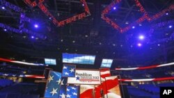 Republican National Committee Chairman Reince Priebus (L) and convention CEO William Harris unveil the stage and podium for the 2012 Republican National Convention, August 20, 2012, at the Tampa Bay Times Forum in Tampa, Florida.