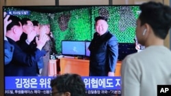 FILE - People watch a TV showing a photo of North Korean leader Kim Jong Un during a news program reporting a North Korean missile launch, May 5, 2019, at the Seoul Railway Station in Seoul, South Korea. 