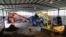 A security officer stands as a heavy vehicle loads the trash into a machine that produces Refuse Derived Fuel at the Bantar Gebang landfill in Bekasi, West Java province, Indonesia, Aug. 12, 2021.