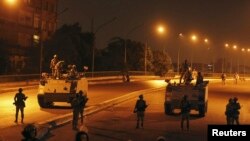 Army troops take positions on a bridge not far from members of the Muslim Brotherhood standing guard around Cairo University and Nahdet Misr Square in Giza, on the outskirts of Cairo, Egypt, July 3, 2013. 