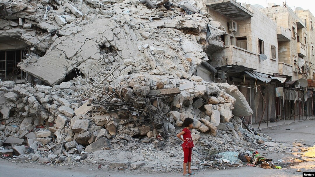 Seorang anak perempuan di depan gedung yang hancur akibat serangan pasukan pemerintah Suriah di kota Ariha, provinsi Idlib. (Foto: Dok)