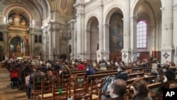 Church-goers wearing face masks attend a church service at Saint-Francois-Xavier church in Paris, France, Nov. 29, 2020.