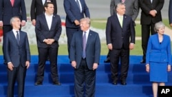 Presiden AS Donald Trump (tengah) tampak tertawa bersama Sekjen NATO Jens Stoltenberg (kiri) dalam KTT NATO di Brussels, 11 Juli 2018 (foto: dok). 