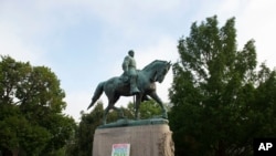 Un cartel con la leyenda Heather Heyer Park, en honor a una activista asesinada por un supremacista blanco en 2017, aparece en la base de la estatua del general confederado Robert E. Lee en el Emancipation Park de Charlottesville, Virginia.