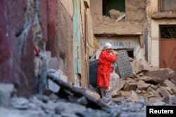 Una mujer saca sus pertenencias de un edificio dañado tras un mortal terremoto en Moulay Brahim, Marruecos, el 10 de septiembre de 2023. REUTERS/Hannah McKay