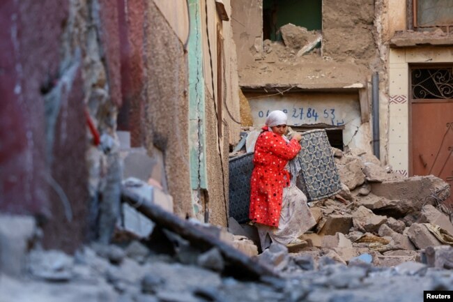Una mujer saca sus pertenencias de un edificio dañado tras un mortal terremoto en Moulay Brahim, Marruecos, el 10 de septiembre de 2023. REUTERS/Hannah McKay