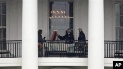Law enforcement officers photograph White House window that was struck by bullet, Nov. 16, 2011.