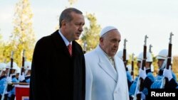 Le pape François et le président turc Recep Tayyip Erdogan marchent devant la garde d'honneur au palais présidentiel à Ankara, le 28 novembre 2014. 