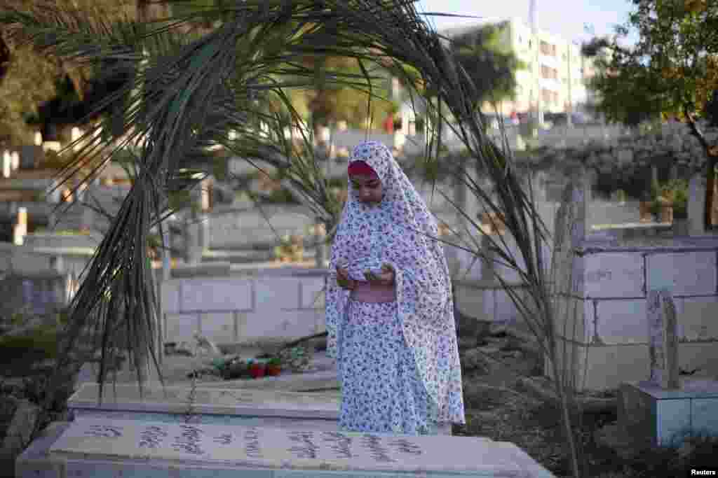 Seorang gadis cilik Palestina memanjaatkan doa di sisi sebuah makam di Ramallah, Tepi Barat, pada hari pertama Idul Fitri.