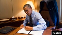 El presidente Barack Obama firma el memorandum relacionado con las acciones ejecutivas sobre inmigración abordo del Air Force One durante su viaje a Las Vegas.